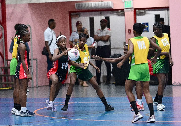GOOD STEAL: Khemyah Anderson, playing the goal defence position for Trinidad and Tobago, intercepts a pass ahead of Dominica’s wing attack Jaycoliah Benjamin, second right, during T&T’s crushing 44-9 win in the Jean Pierre Youth Netball Championships, at The UWI Sports and Physical Education Centre (UWI SPEC), in St Augustine, on Tuesday night. —Photo: JERMAINE CRUICKSHANK (Image obtained at trinidadexpress.com)